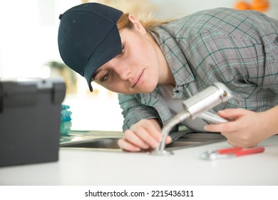 A Woman Fixing Kitchen Sink