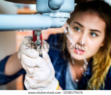 Woman fixing kitchen sink
