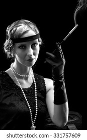 Woman in flapper dress in twenties style smoking a cigarette