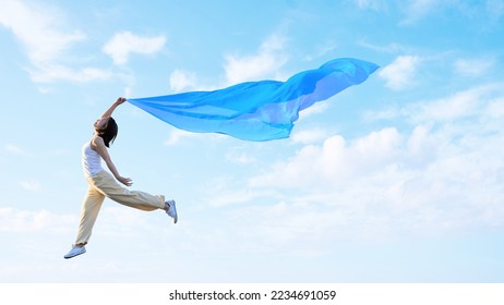 A woman flapping her wings and lightly flying in the sky
