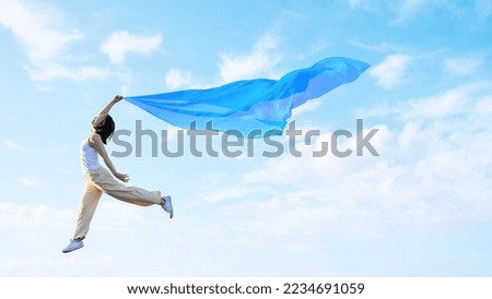 A woman flapping her wings and lightly flying in the sky
