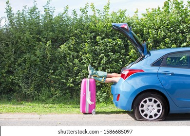 Woman With Flat Tyre On Car Resting Feet On Suitcase