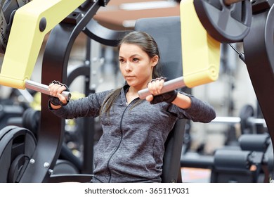 Woman Flexing Muscles On Chest Press Gym Machine 