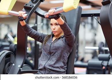 Woman Flexing Muscles On Chest Press Gym Machine 