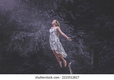 the woman flies towards the incoming light upwards. The forest the woman is in is dark and the forest creatures are trying to keep her down. The woman is a white witch who is running from evil. - Shutterstock ID 2215512817