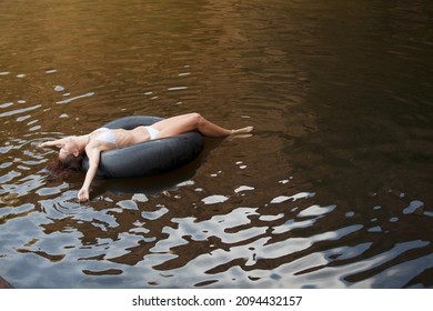 Woman Floating In Inner Tube In River