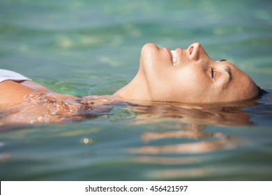 woman floating in the transparent sea