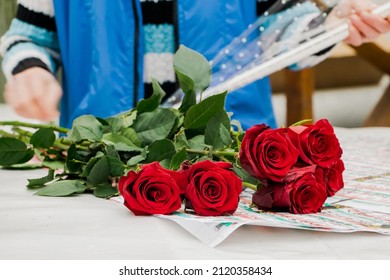 Woman Florist Makes Bouquet Of Red Roses. Small Business For Gardeners. Selling Flowers In Flower Shop. Lifestyle.