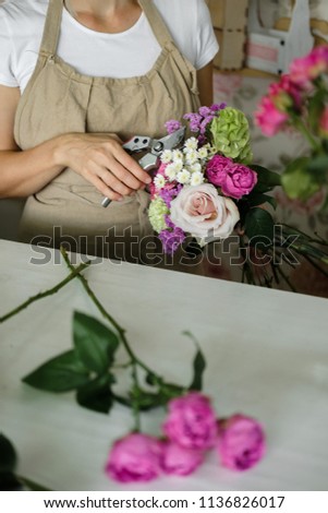 Similar – Woman arranges flower bouquet with roses in vase