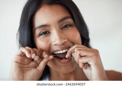 Woman, flossing and tooth in portrait for dental or wellness, morning routine in bathroom for health. Female person, cleaning and mouth for gum hygiene with tape, teeth with results for healthcare - Powered by Shutterstock