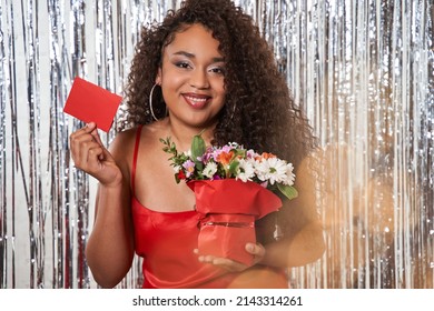 Woman With Flower Bouquet And Card At Her Hands Congratulating Somebody Over Silver Tinsel Curtain