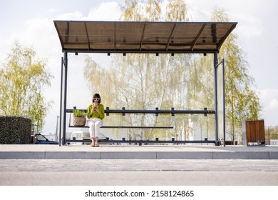 Woman with flowerpot at modern bus stop outdoors, wide front view with copy space. Concept of public transportation and sustainability - Powered by Shutterstock