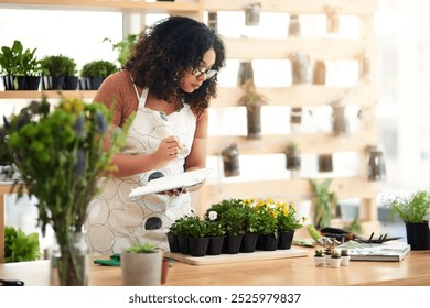 Woman, flowers and nursery with notes as florist for gift, garden and home decor in sustainability. Female person, greenhouse and notebook for inventory, botany and small business in quality control - Powered by Shutterstock