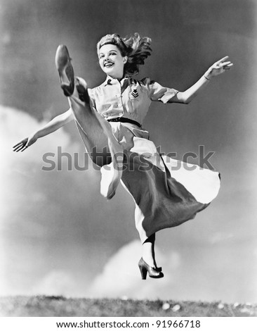 Woman in a flowing dress leaping through the air