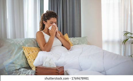 Woman With Flu In Bed, She Use Home Medicine To Handle Sickness. Flu Attack. Sick Woman With Headache Sitting Under The Blanket. Sick Woman With Seasonal Infections, Flu, Allergy Lying In Bed. 