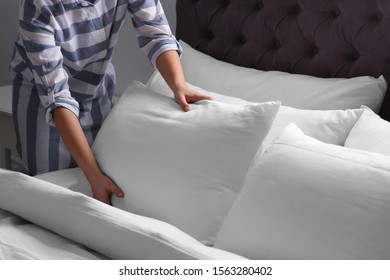 Woman Fluffing White Pillow On Bed, Closeup