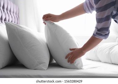 Woman Fluffing White Pillow On Bed, Closeup