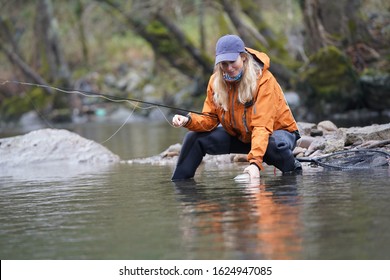 Woman Fly Fishing Catching Rainbow Trout