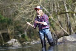 Woman Fly Fishing In River
