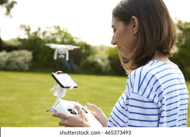 Woman Flying Drone Quadcopter In Garden