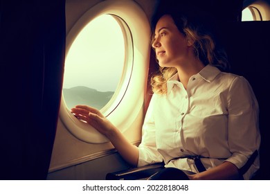 Woman Is Flying As A Passenger In A Plane, Photo In Golden Tones