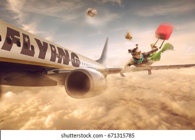 Woman flying in the wing of a moving plane, over clouds with luggage, low cost holiday concept. Photomanipulation