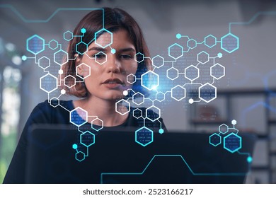 Woman focused on laptop with holographic hexagon data overlay, in a modern office. Concept of digital technology and data analysis
