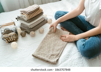 Woman Folding Clothes, Organizing Laundry In Boxes And Baskets. Concept Of Minimalist Lifestyle And Konmari Folding Method. Storage And Arrangement In Wardrobe