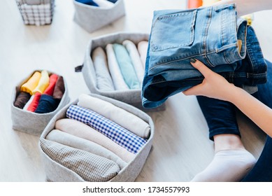 Woman Folding Clothes, Organizing Stuff In Baskets And Boxes. Concept Of Clothes Storage, Minimalism Lifestyle And Japanese T-shirt Folding System. Tidy Up In Wardrobe