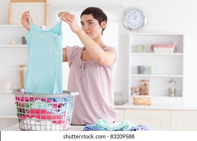 Woman Folding Clothes In A Utility Room