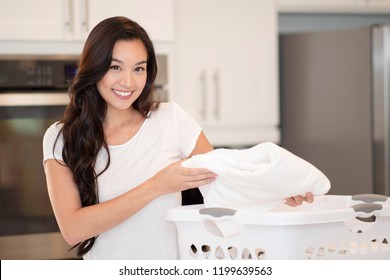 Woman Folding The Laundry In Her Home