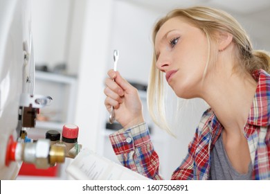 Woman Following Written Instructions To Install Boiler