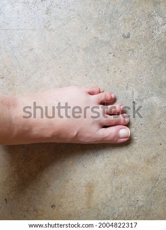 Woman foot skin on concrete floor, abstract textured background