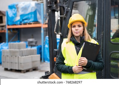 Woman Forklift Truck Driver In An Industrial Area.