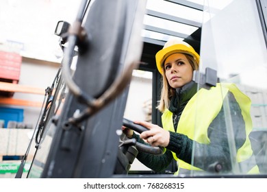 Woman Forklift Truck Driver In An Industrial Area.