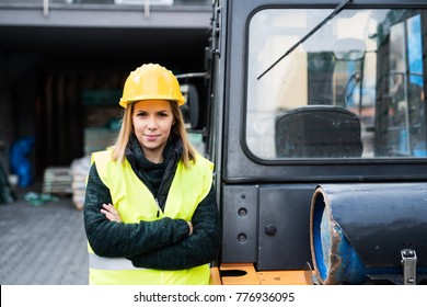 Woman Forklift Truck Driver In An Industrial Area.