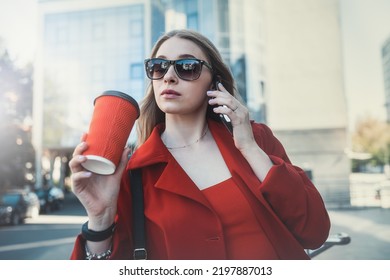 A Woman In A Formal Black Suit Enjoying A Sunny Day And Walking Near The Skyscrapers During A Work Break With A Drink In Her Hand. The Concept Of The Work Of A Woman In The Office