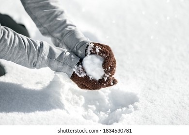 Woman Forming A Snowball For A Funny Fight, Winter Game In The Snow, Copyspace