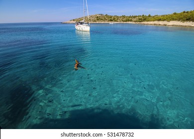 Woman free diving in beautiful blue lagoon.