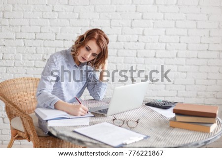 Woman freelancer female hands with pen writing on notebook at home or office