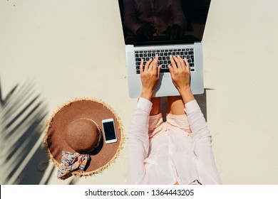 Woman Freelancer Work In Tropics. Blogger Working Remotely On The Laptop Computer Through The Internet. Working While Travelling. Summer Vacation In Seychelles. Top View. White Sand Beach.