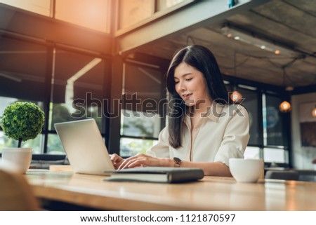 the woman freelancer is working her job on workplace at the coffee shop where she can work independently with the atmosphere warm. 
