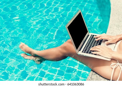Woman Freelancer Working On Her Laptop Computer Sitting At Poolside
