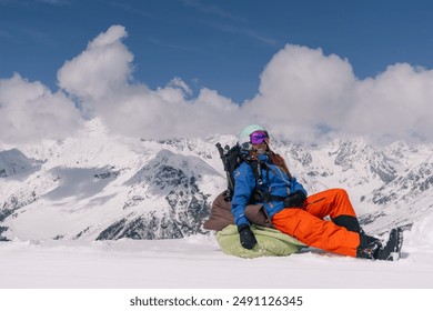 Woman freerider snowboarder sitting on the slope relaxing while skiing off piste  - Powered by Shutterstock