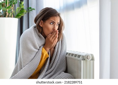 Woman freezing at home, sitting by the cold radiator. Woman with home heating problem feeling cold - Shutterstock ID 2182289751