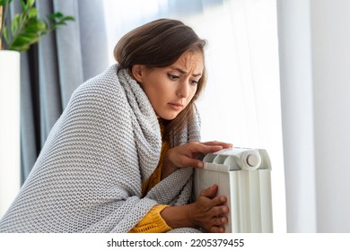 Woman Freezing At Home, Sitting By The Cold Radiator. Woman With Home Heating Problem Feeling Cold