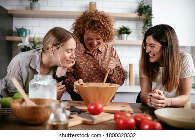 Woman Friends Having Fun In Kitchen. Sisters Cooking Together..