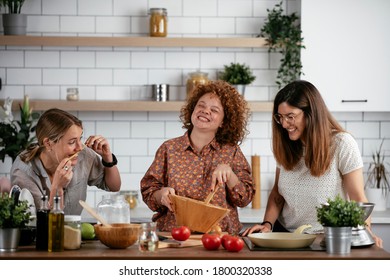 Woman Friends Having Fun In Kitchen. Sisters Cooking Together..