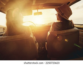 Woman, friends and road trip for sunset travel, summer vacation or holiday relaxing in the car together. Happy women enjoying traveling journey, sunshine or driving freedom with lens flare by a beach - Powered by Shutterstock