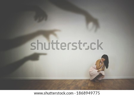 woman frightened by the shadows of hands of demons